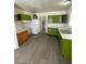 Bright kitchen featuring a mix of wood and green cabinets, with white appliances and vinyl flooring at 2705 Howard Dr, Las Vegas, NV 89104