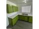 The kitchen features retro-style green cabinetry, white countertops and stainless steel faucet at 2705 Howard Dr, Las Vegas, NV 89104