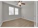 Bedroom with wood laminate flooring, a ceiling fan, and natural light from two windows at 3213 Salutare Ct, North Las Vegas, NV 89031