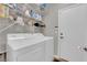 Bright laundry room featuring white washer and dryer, shelving, and ample storage space at 3213 Salutare Ct, North Las Vegas, NV 89031