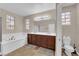 Bright main bathroom with dual sinks, soaking tub, shower, and a toilet at 3213 Salutare Ct, North Las Vegas, NV 89031