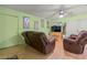 Living room featuring hardwood floor, plush sofas, and soft green walls at 3255 Liahona Way, Las Vegas, NV 89121