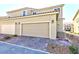 Two-car garage with brick-paved driveway in front of beige two-story townhouse under blue sky at 3732 Via Gennaro, Henderson, NV 89044