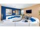 Spacious living room with blue accent walls, recessed lighting, and a large white sectional sofa at 3732 Via Gennaro, Henderson, NV 89044