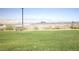 Picturesque park area with a bench, lush green grass, mountain views, and a fenced perimeter at 3732 Via Gennaro, Henderson, NV 89044