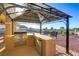 Outdoor kitchen featuring a built-in grill and beverage cooler under a shaded pergola with views at 402 E Country Club Dr, Henderson, NV 89015