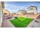 Private backyard with brick patio, artificial grass, and seating area at 4364 Contour Bend Ave, North Las Vegas, NV 89084