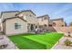 Spacious backyard with synthetic lawn, patio area with outdoor furniture, and well-maintained landscaping at 4364 Contour Bend Ave, North Las Vegas, NV 89084