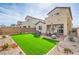 Spacious backyard with synthetic lawn, a covered patio, and stone landscaping at 4364 Contour Bend Ave, North Las Vegas, NV 89084