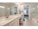 Bright bathroom featuring dual sinks, a glass shower, and an adjoining room view at 4364 Contour Bend Ave, North Las Vegas, NV 89084