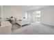 Bright bedroom with neutral carpet, white furnishings and sliding glass doors to a balcony at 4364 Contour Bend Ave, North Las Vegas, NV 89084