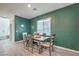 Cozy dining room features dark green accent wall, modern table and chairs, and bright natural light at 4364 Contour Bend Ave, North Las Vegas, NV 89084