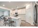 Contemporary kitchen features a center island with bar seating, stainless steel appliances, and white cabinetry at 4364 Contour Bend Ave, North Las Vegas, NV 89084