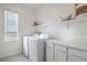 Well-lit laundry room with a washer, dryer, and white cabinetry at 4364 Contour Bend Ave, North Las Vegas, NV 89084