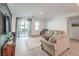Cozy living room with wood floors, a plush sofa, and sliding glass doors to the outdoor space at 4364 Contour Bend Ave, North Las Vegas, NV 89084