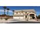 Two-story home with a three-car garage and desert landscaping under a clear blue sky at 4798 Luna Ridge Ct, Las Vegas, NV 89129