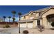 Two-story home with a three-car garage and desert landscaping under a clear blue sky at 4798 Luna Ridge Ct, Las Vegas, NV 89129