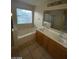 This bathroom features a vanity sink, tiled flooring, a soaking tub, and a glass shower at 5413 Bristol Bend Ct, Las Vegas, NV 89135