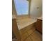 Inviting bathtub in a bathroom with tile flooring, vanity, and a window for natural light at 5413 Bristol Bend Ct, Las Vegas, NV 89135
