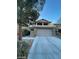 Two-story home with a two-car garage, stone accents, and manicured landscaping at 5413 Bristol Bend Ct, Las Vegas, NV 89135