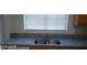 Close-up of the kitchen sink with granite countertops and wood cabinets at 5413 Bristol Bend Ct, Las Vegas, NV 89135