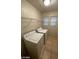 Bright laundry room with a washer, dryer, storage shelf, tile floor, and two windows for great natural light at 5413 Bristol Bend Ct, Las Vegas, NV 89135