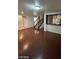 Open-concept living area with wood floors, staircase, and a view into the kitchen at 5413 Bristol Bend Ct, Las Vegas, NV 89135