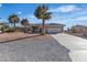 Single story home with desert landscaping, a large front yard, and a long driveway to the garage at 5841 Doubletree Rd, Pahrump, NV 89061
