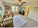 Bright Bedroom features a ceiling fan, carpet, window, and a crib, creating a cozy atmosphere for a baby's room at 6145 Scarlet Leaf St, Las Vegas, NV 89148
