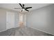 Spacious bedroom with gray carpet, ceiling fan, white doors, and ample natural light at 6221 Desert Orchid Way, Las Vegas, NV 89141