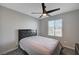 Cozy bedroom with a black bed frame, gray carpet, and natural light from the window at 6221 Desert Orchid Way, Las Vegas, NV 89141