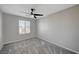 Bright bedroom with ceiling fan, gray carpet, light walls, and a window with blinds at 6221 Desert Orchid Way, Las Vegas, NV 89141