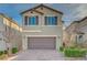 Charming two-story home featuring a brown two-car garage, complemented by brick driveway and desert landscaping at 6221 Desert Orchid Way, Las Vegas, NV 89141