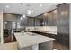Modern kitchen featuring granite countertops, stainless appliances, dark cabinetry, and an island with a sink at 6221 Desert Orchid Way, Las Vegas, NV 89141