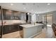 Bright kitchen with dark wood cabinets, granite countertops, and a central island, open to the living area at 6221 Desert Orchid Way, Las Vegas, NV 89141