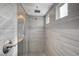 Walk-in shower featuring light gray tile, dual shower heads, and a modern, sleek design at 6221 Desert Orchid Way, Las Vegas, NV 89141