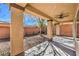 Covered outdoor patio area with a ceiling fan and view of the backyard and exterior brick wall at 7315 Summer Air Ave, Las Vegas, NV 89179