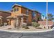 Inviting two-story home featuring stone accents, desert landscaping, and a charming covered entrance at 7440 Cobbhan Dr, Las Vegas, NV 89179