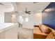 Upstairs loft area with a tan couch and a navy accent wall, along with a ceiling fan at 7440 Cobbhan Dr, Las Vegas, NV 89179