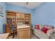 Bright bedroom featuring blue walls, a ceiling fan, a window, and a desk with shelves at 7669 Fieldfare Dr, North Las Vegas, NV 89084