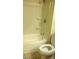 Bathroom featuring a toilet, shower-tub combo with a tile surround and some shelving at 7963 Laurena Ave, Las Vegas, NV 89147