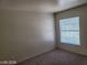 Neutral bedroom with plush carpeting and a window bringing in natural light at 7963 Laurena Ave, Las Vegas, NV 89147