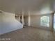Bright and airy living area with tile floors, natural light, and staircase at 7963 Laurena Ave, Las Vegas, NV 89147