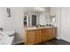 Bright bathroom featuring double sinks, vanity, soaking tub, and a large mirror at 8124 Loma Del Ray St, Las Vegas, NV 89131