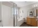 Bright bathroom featuring a tiled shower, soaking tub, vanity with wood cabinets and large mirror at 8124 Loma Del Ray St, Las Vegas, NV 89131