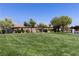Exterior view of grassy common area in community, featuring a verdant lawn and mature trees at 8124 Loma Del Ray St, Las Vegas, NV 89131