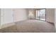 Bright living room with neutral carpet and sliding glass door access to the balcony at 8250 N Grand Canyon Dr # 2059, Las Vegas, NV 89166