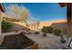 Charming backyard featuring gravel, planter box, mature trees, and brick perimeter wall at 8856 Timber Mesa St, Las Vegas, NV 89139