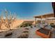 Landscaped backyard with a covered patio, gravel, planter box, and comfortable seating area at 8856 Timber Mesa St, Las Vegas, NV 89139
