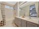 Bathroom features a tub with shower and dual sink vanity with granite countertop and large mirror at 8856 Timber Mesa St, Las Vegas, NV 89139